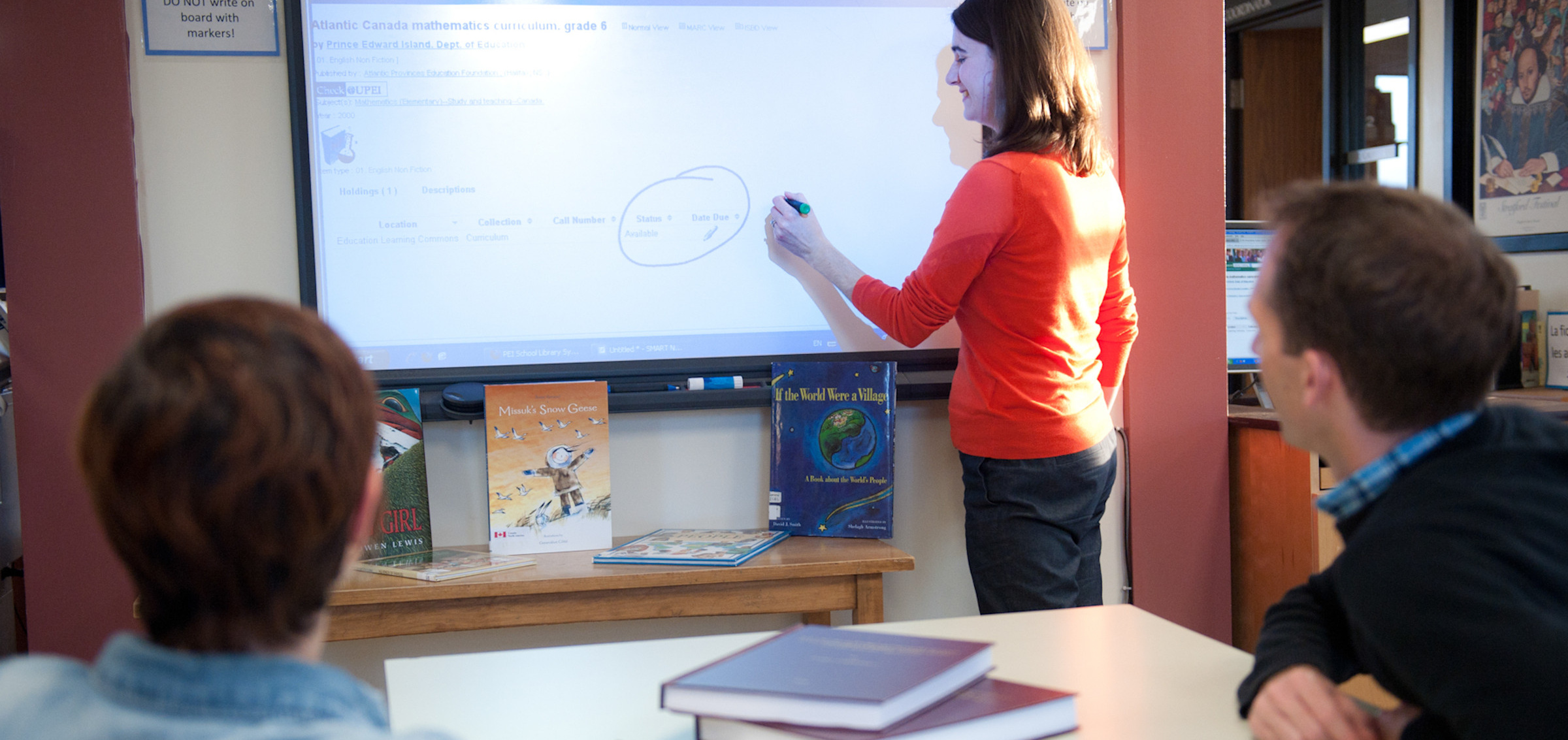 A woman writes on a smart board