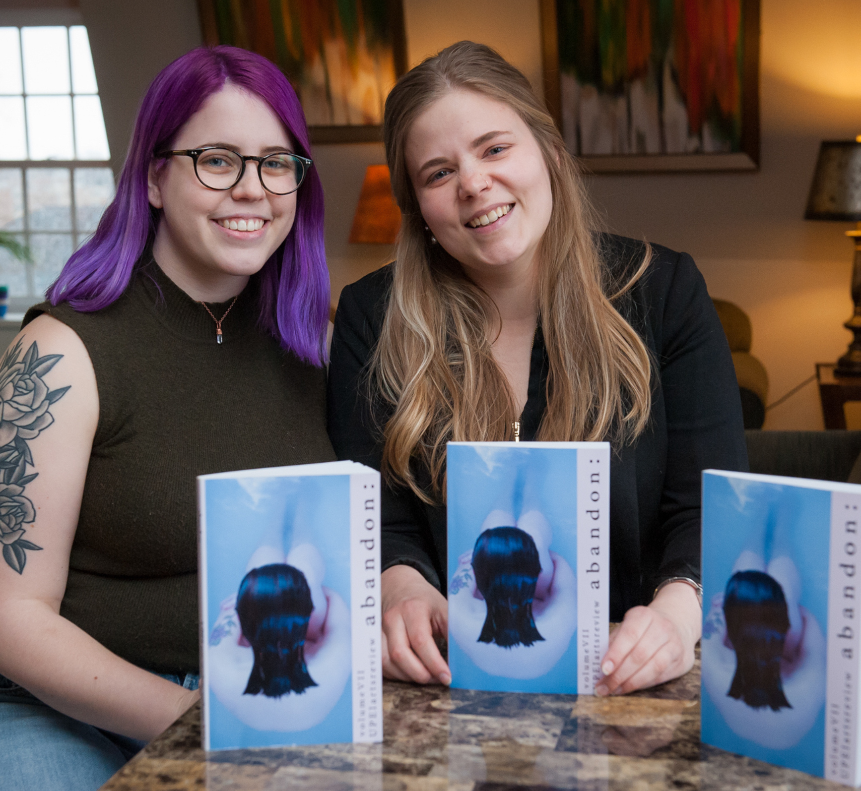 students sit at a table with the BCA Arts Review publication