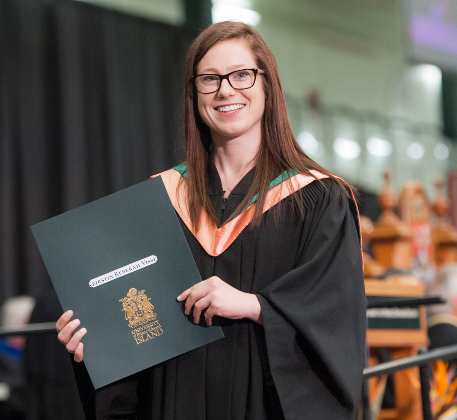 A graduate stands with her degree