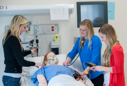 three nursing students with clinical mannequin