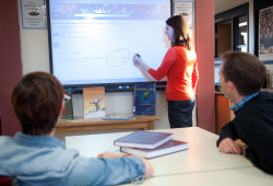 A woman writes on a smart board