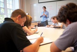 A professor speaks at the front of a classroom