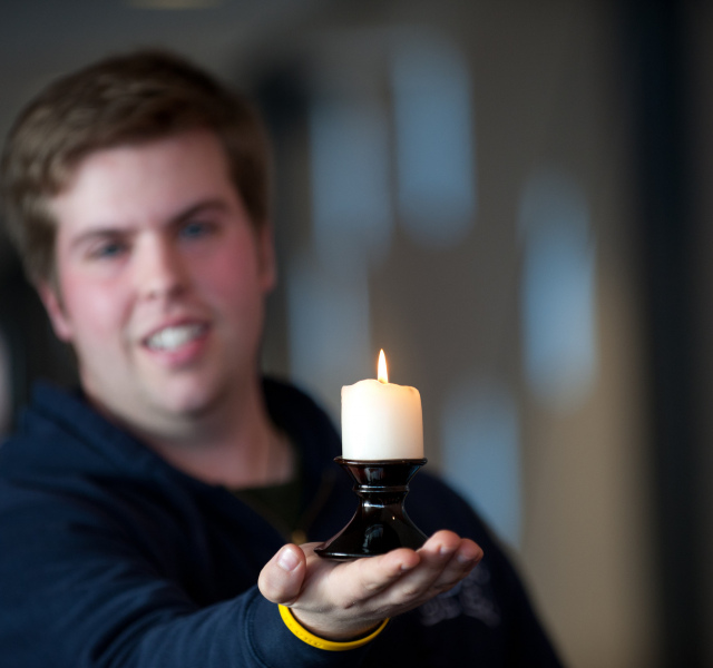 A student holds a candle