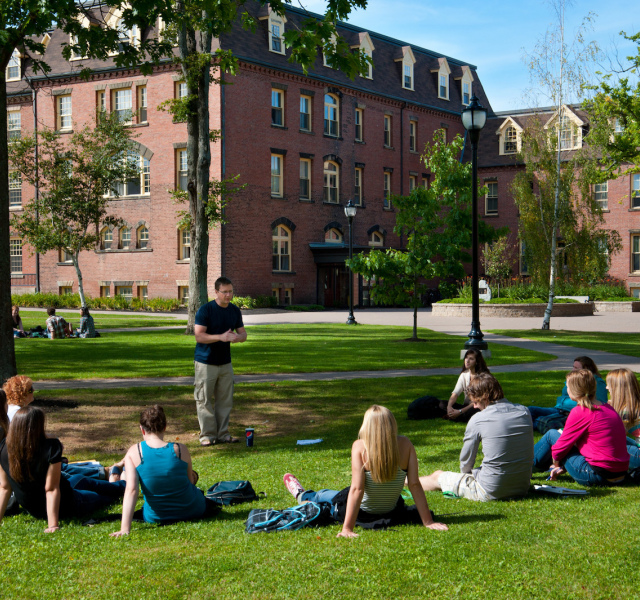 students listening to an outdoor lecture in the quad